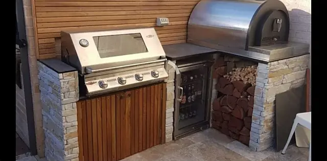 Outdoor kitchen with built-in BBQ and wood store