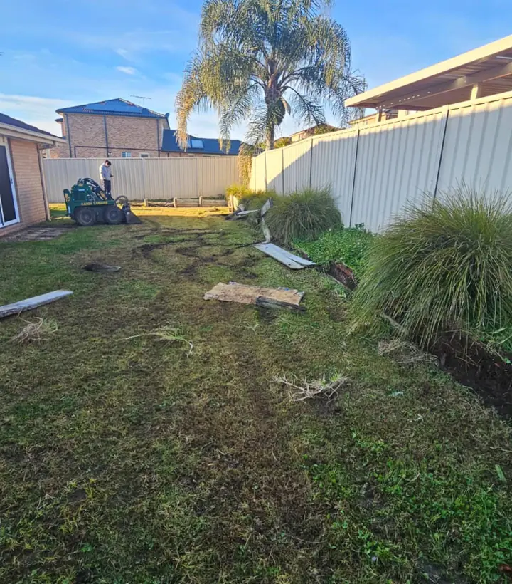 Backyard mid-clearing with a mini loader, old timber sleepers pulled out